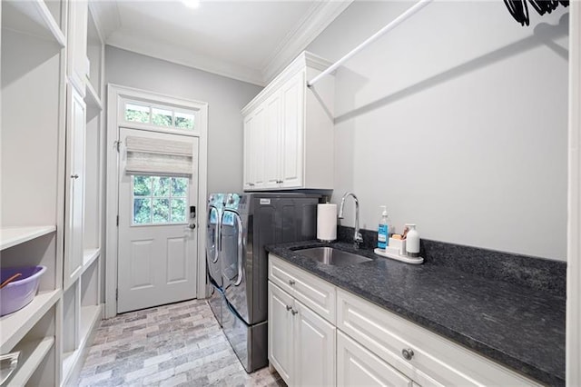 clothes washing area with sink, cabinets, crown molding, and independent washer and dryer