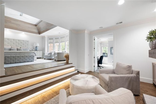 bedroom with ornamental molding, a tray ceiling, and wood-type flooring