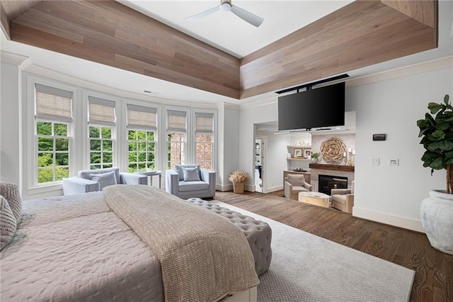 bedroom featuring dark hardwood / wood-style flooring, a raised ceiling, and ceiling fan