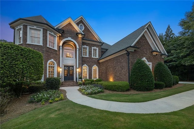 view of front of house with french doors and a yard