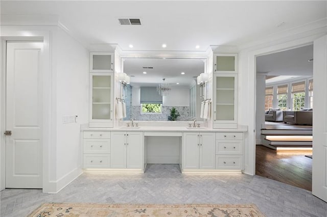 bathroom with vanity, ornamental molding, and tasteful backsplash