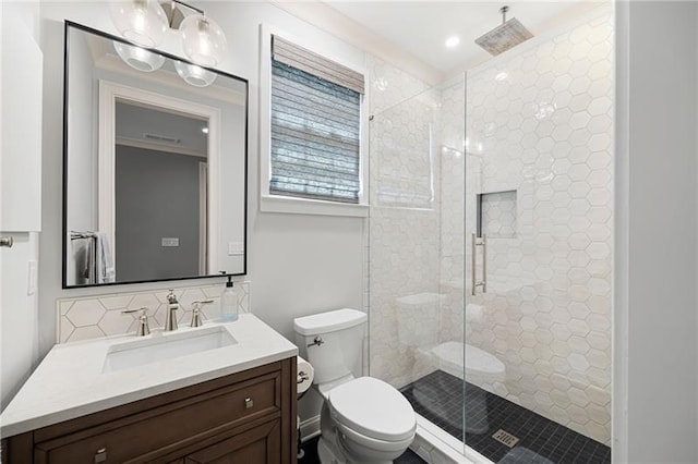 bathroom featuring toilet, an enclosed shower, vanity, and tasteful backsplash