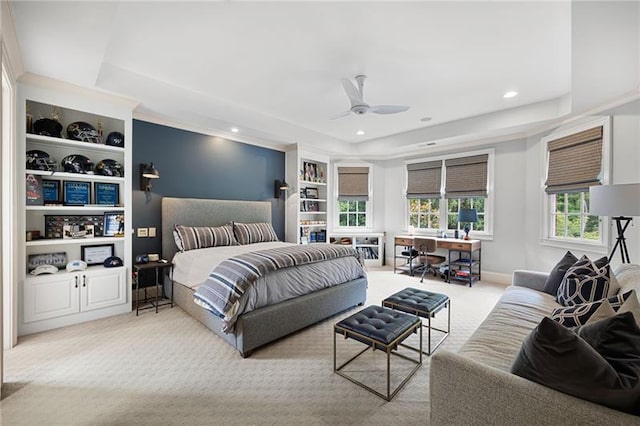 bedroom with ceiling fan, light colored carpet, and a raised ceiling