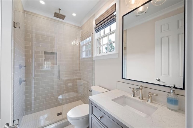 bathroom with toilet, ornamental molding, a shower with shower door, and vanity