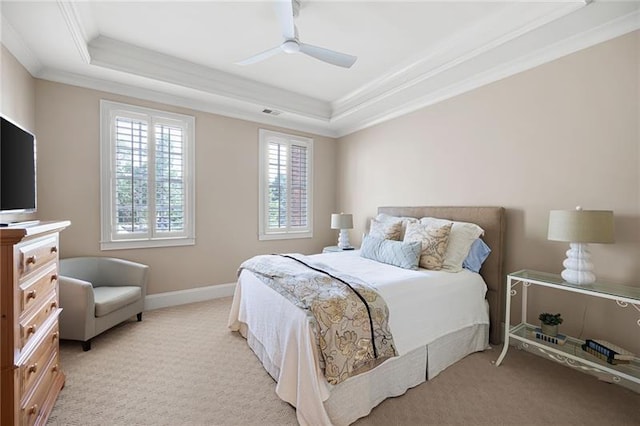 carpeted bedroom with crown molding, ceiling fan, and a tray ceiling