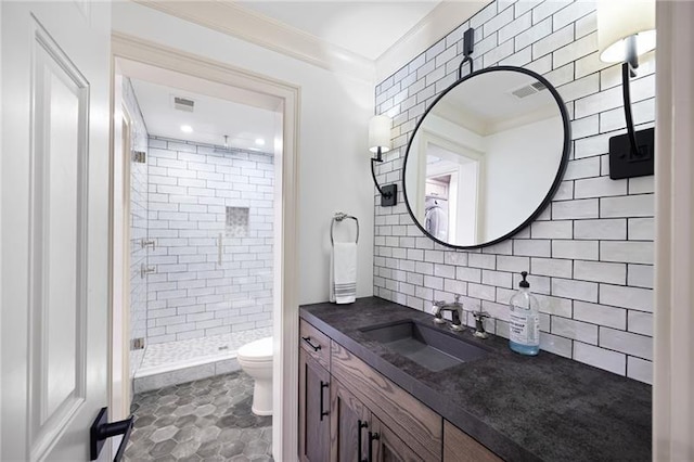 bathroom featuring toilet, decorative backsplash, tile patterned floors, an enclosed shower, and vanity