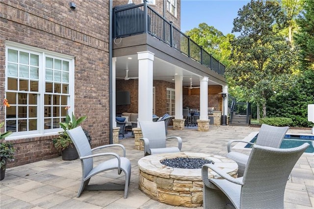 view of patio / terrace featuring a fire pit and a balcony