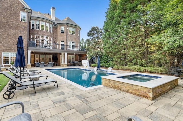 view of pool with a patio and an in ground hot tub