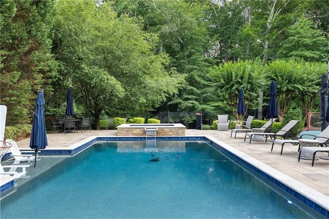 view of pool with a patio and an in ground hot tub