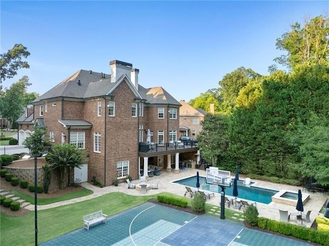 view of swimming pool with basketball court, a patio area, a lawn, and an in ground hot tub