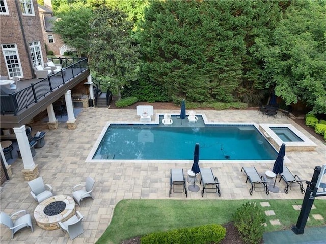 view of swimming pool with a patio, an outdoor fire pit, and an in ground hot tub