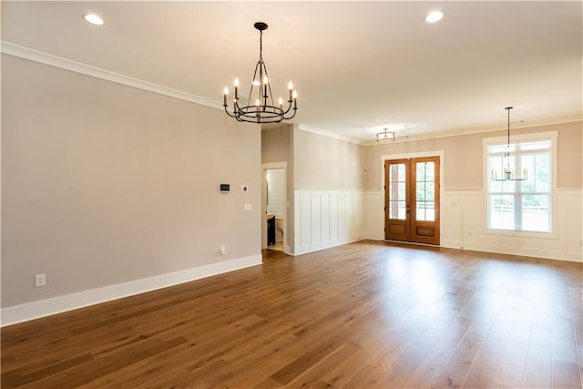empty room featuring dark wood-style flooring, crown molding, wainscoting, a chandelier, and recessed lighting