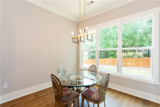 dining room with baseboards, a chandelier, ornamental molding, and visible vents