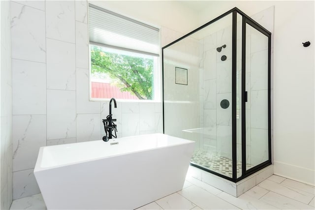 bathroom with a soaking tub, a stall shower, and marble finish floor