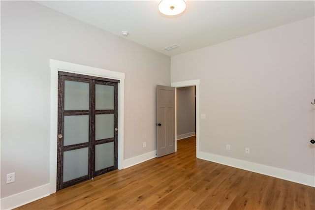unfurnished room with baseboards, light wood finished floors, and visible vents
