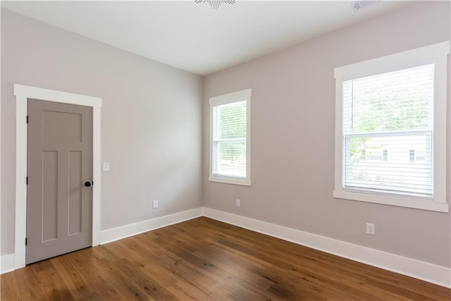 empty room featuring baseboards and wood finished floors