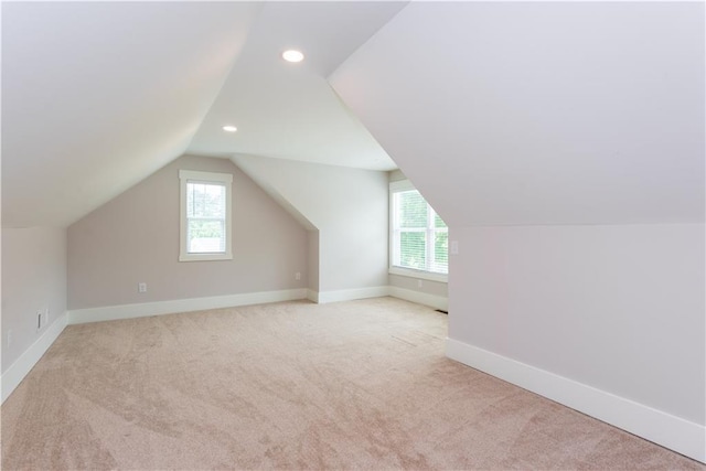 bonus room with baseboards, vaulted ceiling, and light colored carpet