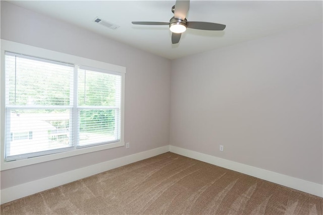 spare room featuring ceiling fan, visible vents, baseboards, and carpet