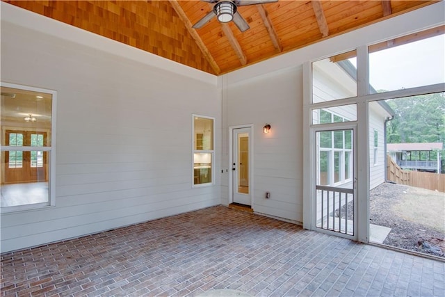 unfurnished room with wood ceiling, a ceiling fan, high vaulted ceiling, wooden walls, and brick floor