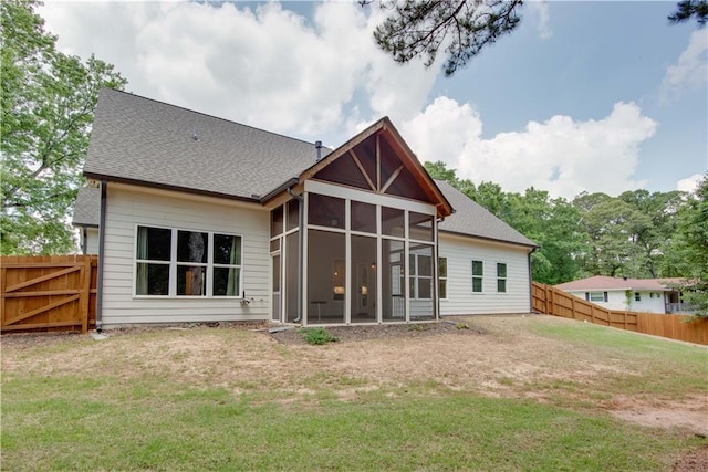 back of house with a sunroom, a fenced backyard, and a lawn