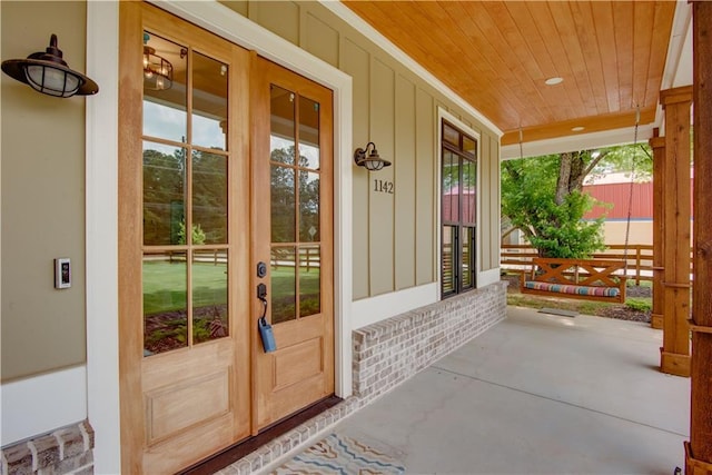 property entrance with french doors, board and batten siding, and a porch