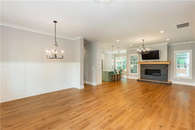 unfurnished living room with a notable chandelier, visible vents, and light wood-type flooring