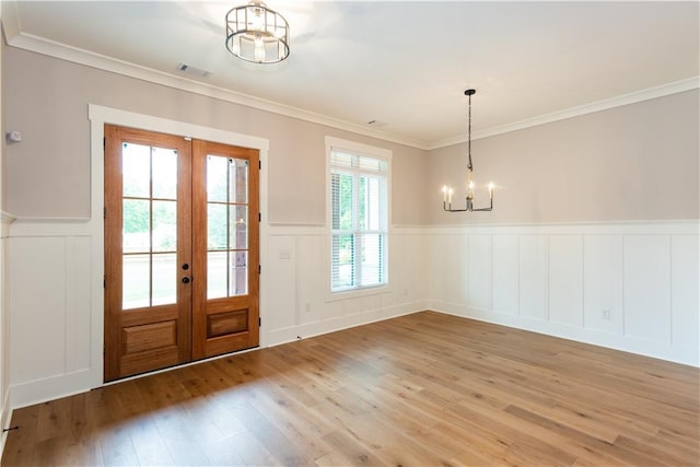 doorway to outside featuring an inviting chandelier, visible vents, a decorative wall, light wood-type flooring, and french doors