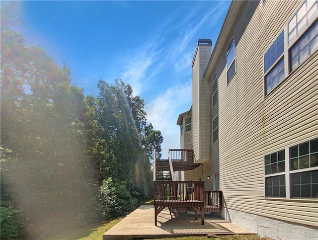 view of side of property featuring a wooden deck and a patio