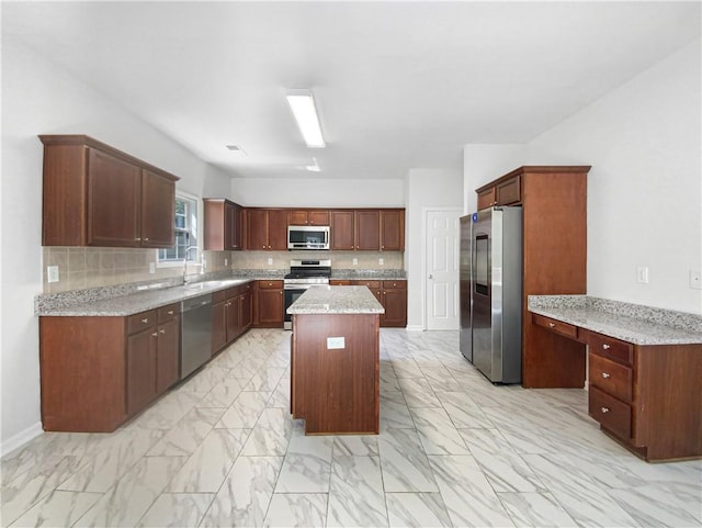 kitchen with decorative backsplash, light stone counters, stainless steel appliances, a center island, and sink