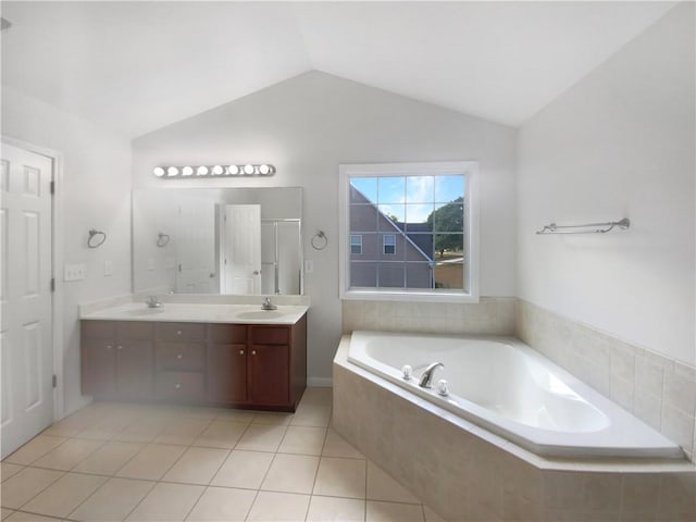 bathroom with tile patterned floors, vaulted ceiling, vanity, and separate shower and tub