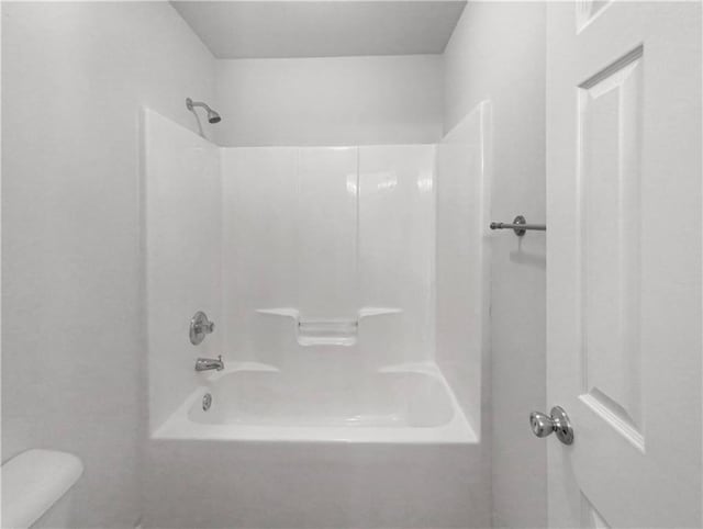 bathroom featuring bathing tub / shower combination and toilet