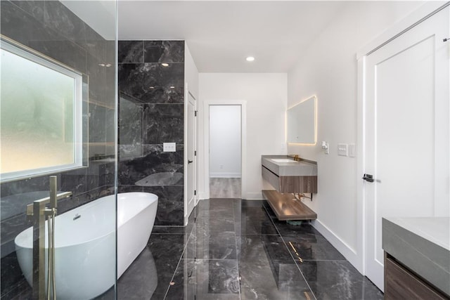 bathroom featuring tile walls, vanity, and a washtub