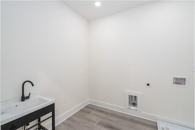 laundry room featuring sink, hookup for a washing machine, light hardwood / wood-style floors, and hookup for an electric dryer