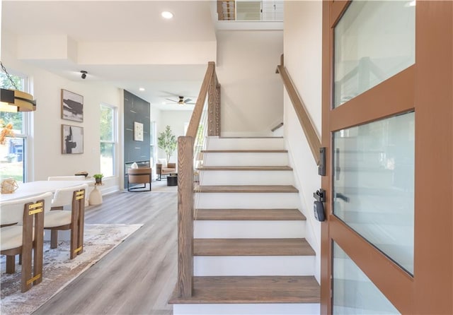 stairway with ceiling fan and hardwood / wood-style floors