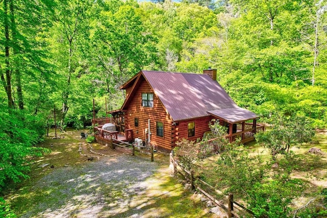 369 Trillium Rd, Suches, GA 30572 - view of side of home featuring a wooden deck, a chimney, log siding, a wooded view, and metal roof