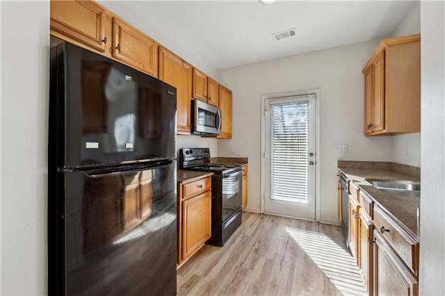 kitchen with sink, light hardwood / wood-style flooring, and black appliances