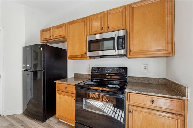 kitchen featuring light hardwood / wood-style flooring and black appliances