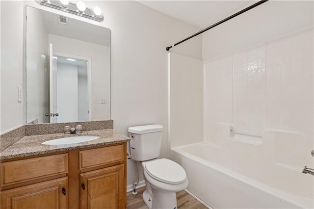 full bathroom with toilet, wood-type flooring, vanity, and washtub / shower combination