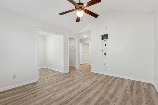 spare room featuring ceiling fan, light wood-type flooring, and vaulted ceiling