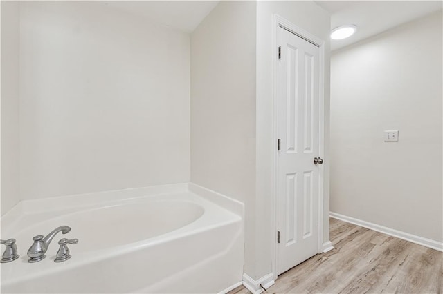 bathroom featuring wood-type flooring and a bathing tub