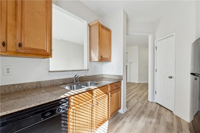 kitchen with black dishwasher, light hardwood / wood-style floors, and sink