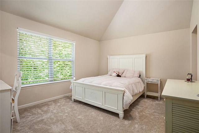 bedroom featuring lofted ceiling, light colored carpet, and baseboards