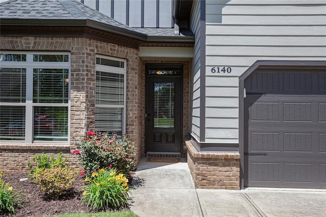 doorway to property featuring roof with shingles