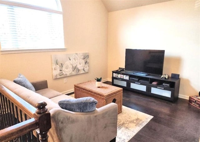 living room with plenty of natural light, wood finished floors, baseboards, and lofted ceiling