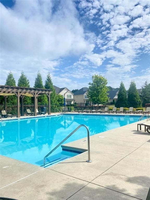 community pool featuring a pergola, fence, and a patio