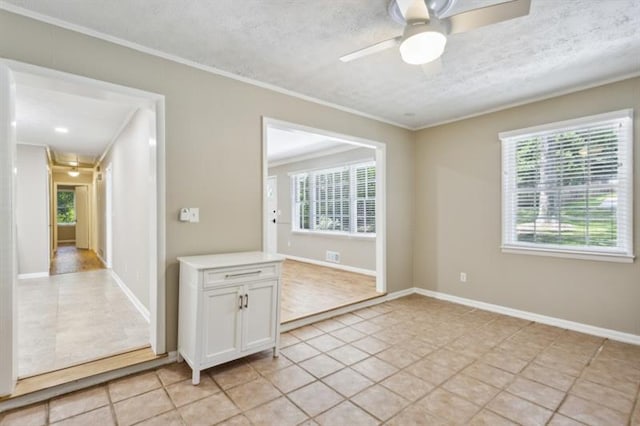 tiled spare room with a textured ceiling, ceiling fan, and ornamental molding