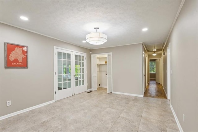 spare room with french doors and a textured ceiling