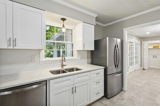 kitchen featuring white cabinets, stainless steel appliances, crown molding, sink, and decorative light fixtures