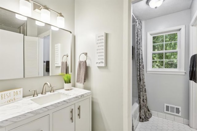 bathroom with tile patterned flooring, shower / bath combo, and vanity