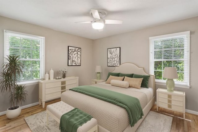 bedroom with ceiling fan, light wood-type flooring, and multiple windows